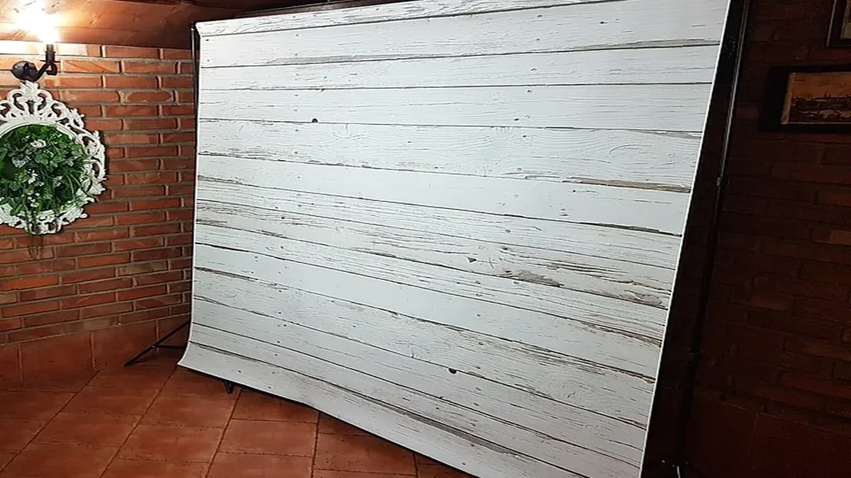 Fotomatón de tótem abierto con impresora junto a un photocall en el salón de una boda